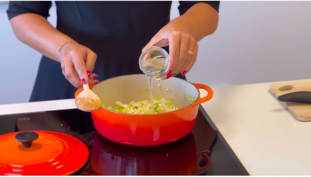 Regue com o vinho branco e deixe evaporar, mexendo suavemente.