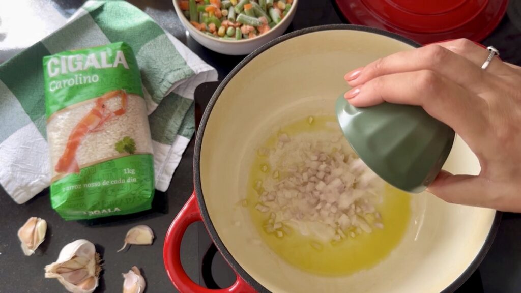 Num tacho, aqueça o azeite e adicione os alhos e a cebola picados.