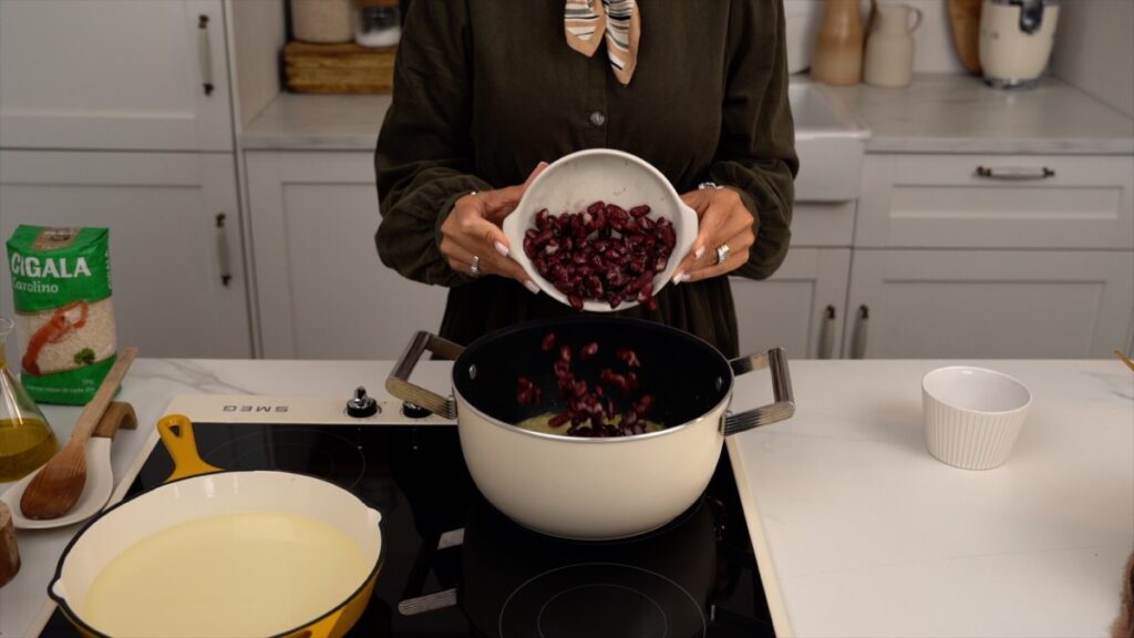 Quando o arroz estiver quase pronto, junte o feijão cozido e misture delicadamente.