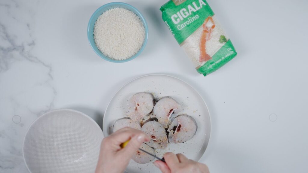 Num prato, tempere as postas de pescada com sal, pimenta, alho em pó e sumo de limão, cobrindo ambos os lados.